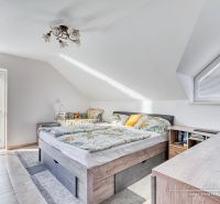 Helles Dachbodenschlafzimmer mit bequemem Bett und Aussicht, Einfamilienhaus.