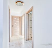 Flur in einem Einfamilienhaus mit Fliesen, Holztüren und stilvoller Beleuchtung.
