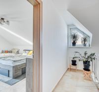 Dachbodenschlafzimmer mit Bett und Fenster, Pflanzen auf der Treppe, Einfamilienhaus.