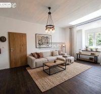 Wohnzimmer einer 3-Zimmer-Wohnung mit Holzboden und großem Fenster.