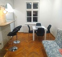 Essbereich mit weißem Tisch, grauen Stühlen und einem Boden in Holzoptik in einer Zweizimmerwohnung.