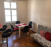Essbereich in einer 2-Zimmer-Wohnung mit Holzboden und stilvollen Sitzgelegenheiten.