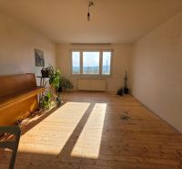 Ein heller Raum mit einem Klavier und einem Holzboden in einer 4-Zimmer-Wohnung.
