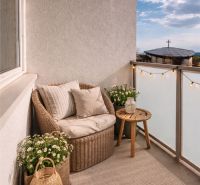Balkon einer 4-Zimmer-Wohnung mit Rattanmöbeln und Dekorationen in einem angenehmen Stil.