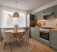 Küche in einer 4-Zimmer-Wohnung mit Holzboden und rundem Tisch.