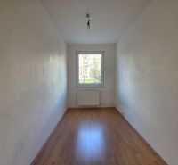 Ein leerer Raum mit Holzboden in einer 4-Zimmer-Wohnung.