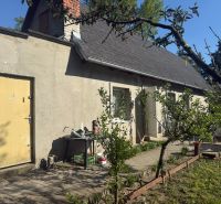 Vor dem Haus in der Straße Sekule in Sekule stehen Bäume und Gartenmöbel.