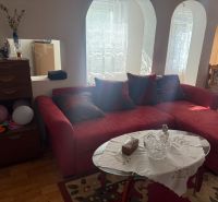 Rotes Sofa in einer Hütte mit Holzboden und Glastisch.
