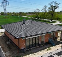Der Bau eines Einfamilienhauses in Bernolákovo mit Flachdach, umgeben von grünen Feldern.