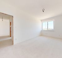 Ein leerer Raum mit weißen Wänden und einem Fenster in einem neu gebauten Einfamilienhaus.
