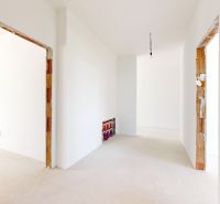Innenraum eines Einfamilienhauses mit weißen Wänden und Vorbereitung für Elektroinstallationen.