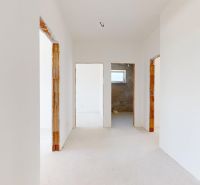 Flur im Einfamilienhaus mit weißen Wänden und hellem Boden in Holzoptik.
