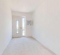 Geräumiger Flur in einem Einfamilienhaus mit weißen Wänden und Glastüren.