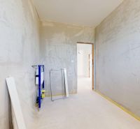 Unvollständiger Innenraum mit Betonwänden und Elementen für Sanitäranlagen in einem Einfamilienhaus.