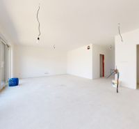 Unvollendetes Interieur eines Einfamilienhauses mit großen Fenstern und einem geräumigen Raum.