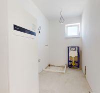 Ein leerer Raum mit einem Kessel und Vorbereitung für sanitäre Anlagen in einem Einfamilienhaus.