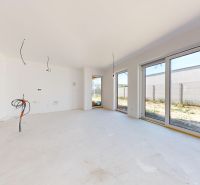 Helles Interieur eines Einfamilienhauses mit großen Fenstern und weißen Wänden.