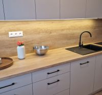 Küche in einer 3-Zimmer-Wohnung mit Holzboden, heller Küchenzeile und schwarzem Spülbecken.