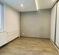 Ein leerer Raum mit einem Schrank und einem Boden in Holzoptik in einer 4-Zimmer-Wohnung.