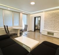 Wohnzimmer einer 4-Zimmer-Wohnung mit Holzboden, Sofa und Essecke.