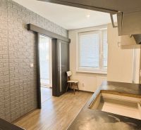 Küche in einer 4-Zimmer-Wohnung mit Holzboden und Ziegelverkleidung an der Wand.