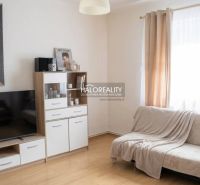 Wohnzimmer in einem Einfamilienhaus mit Holzboden und heller Couch.