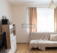 Wohnzimmer in einem Einfamilienhaus mit Holzboden und hellen Vorhängen.