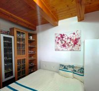 Schlafzimmer in einem Einfamilienhaus mit einer Vitrine für Automodelle und einer Holzdecke.