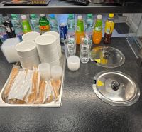 Innenraum von Gastronomiebereichen mit Getränken, Gläsern, Schalen und Besteck, die zum Servieren bereit sind.