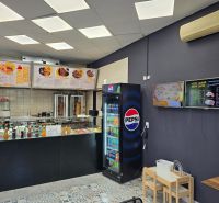 Gastronomiebereiche mit Verkauf von Getränken und Speisen, Boden mit Holzdekor, Speisekarte an den Wänden.