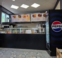 Gastroräume mit einem Getränkeangebot, einem Pepsi-Kühlschrank und Fliesen mit Ornamenten.