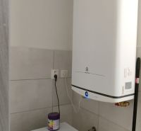 Waschmaschine und Boiler im Badezimmer einer 2-Zimmer-Wohnung mit praktischer Anordnung.