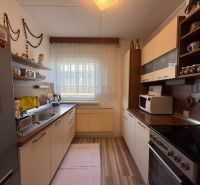 Eine Küche in einem Einfamilienhaus mit einem Holzboden und weißen Schränken.