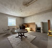 Wohnzimmer eines Einfamilienhauses mit einem ovalen Tisch und einem Teppich auf dem Boden.