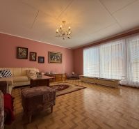 Wohnzimmer in einem Einfamilienhaus mit Holzboden und bequemen Sitzgelegenheiten.