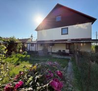 Ein Einfamilienhaus in Zlaté Moravce mit einem blühenden Garten und einem gepflegten Rasen.