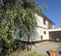 Ein Einfamilienhaus in Zlaté Moravce mit Garage und Terrasse, umgeben von Grün und Bäumen.