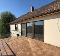 Ein Einfamilienhaus in Zlaté Moravce mit Terrasse und brauner Dacheindeckung.