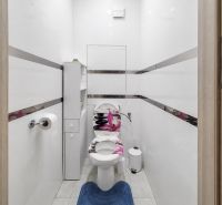 Ein Badezimmer in einer 3-Zimmer-Wohnung mit weißen Wänden und einer weißen Toilette.