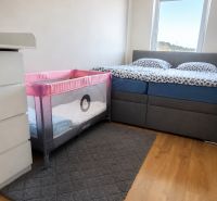 Schlafzimmer mit Kinderbett in einer 3-Zimmer-Wohnung, Boden mit Holzdekor.