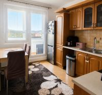 Küche in einer 3-Zimmer-Wohnung mit Holzschränken, Esstisch und großem Fenster.