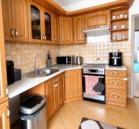 Küche in einer 3-Zimmer-Wohnung mit Holzelementen und Geräten.