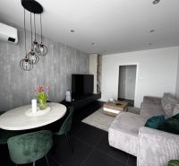 Wohnzimmer in einer 3-Zimmer-Wohnung mit einem bequemen Sofa und einem Esstisch.