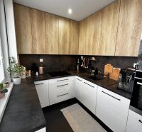 Küche mit weißen Schränken und Holzelementen in einer 3-Zimmer-Wohnung.