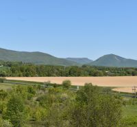 Die malerische Landschaft bei Rožňava mit Feldern, einer Straße und Hügeln in der Ferne.