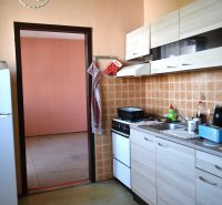 Küche in einer 3-Zimmer-Wohnung mit Fliesenverkleidung und Boden in Holzoptik.