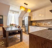 Küche in einer 4-Zimmer-Wohnung mit Esstisch, Kronleuchter und modernen Geräten.
