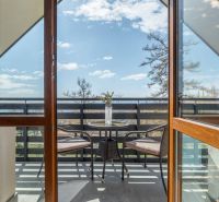 Ein Balkon mit einem Tisch und Stühlen in einer 4-Zimmer-Wohnung in Vyšné Hágy.