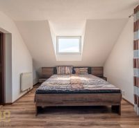 Ein stilvolles Schlafzimmer mit einem großen Bett und einem Boden in Holzoptik in einer 4-Zimmer-Wohnung.