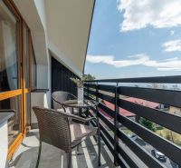 Ein Balkon mit Rattan-Sitzmöbeln und Blumendekoration in einer 4-Zimmer-Wohnung in Vyšné Hágy.